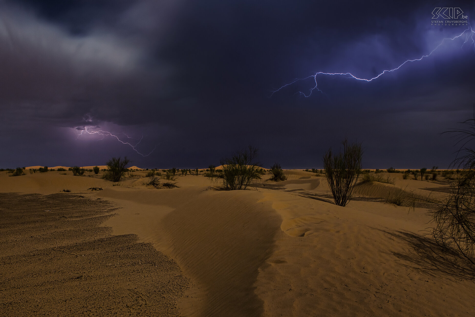 Lightning in the desert During our 5 day hike in the Grand Erg Oriental we always slept under the starry sky. Our first night was memorable because it was full moon with a cloudy sky, some rain showers and a lot of thunder and lightning. When the rain stopped I woke up to try to make some photos of the lightning. I made several photos but this is definitely my best photo, quite unique shot I think. Stefan Cruysberghs